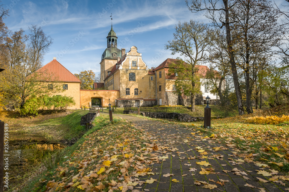 View of Lielstraupe Castle on a sunny autumn day.  Latvia, Baltic. One of the medieval castles of Latvia that has survived till nowadays and united in one corps with the church.
