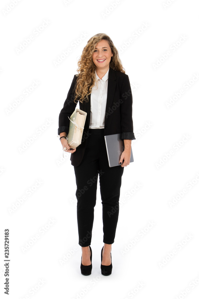 Businesswoman standing in the studio with computer and documents under her arms, she is wearing a black suit and a white shirt Businesswoman standing in the studio with computer and documents under her arms, she is wearing a black suit and a white shirt