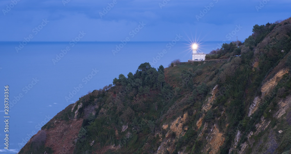 Light in the lighthouse of Mount Igueldo with the sea in the background, city of Donostia, Euskadi