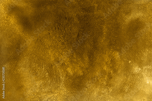 Gold watercolor texture with abstract washes and brush strokes on the white paper background.