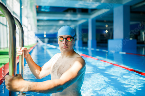 Photo of young swimmer man coming out of indoor pool © Sergey