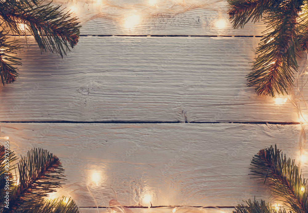 Φωτογραφία Picture of Christmas wooden gray surface with burning garland, branches of spruce