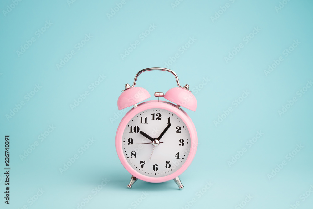 Pink alarm clock on blue background - obrazy, fototapety, plakaty 