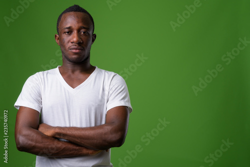 Studio shot of young African man against green background
