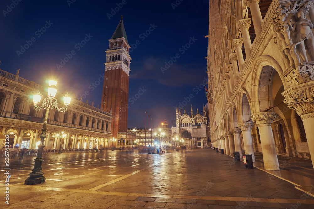 Bell tower and historical buildings at night at Piazza San Marco in Venice