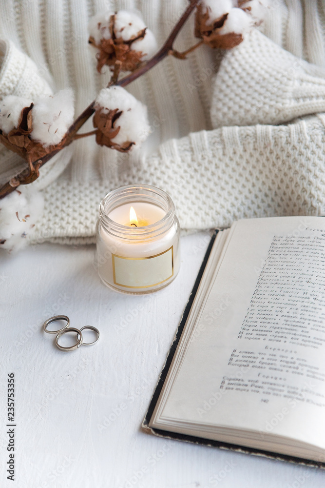 objects laid out on the table, an open book and a burning candle objects laid out on the table, an open book and a burning candle