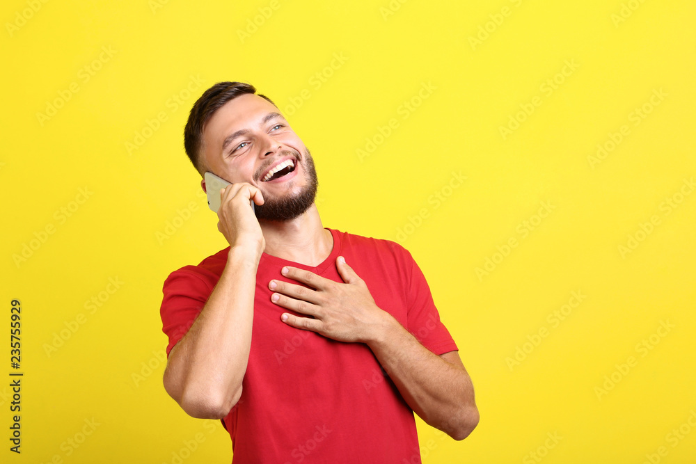 Young man talking on a mobile phone on yellow background Young man talking on a mobile phone on yellow background