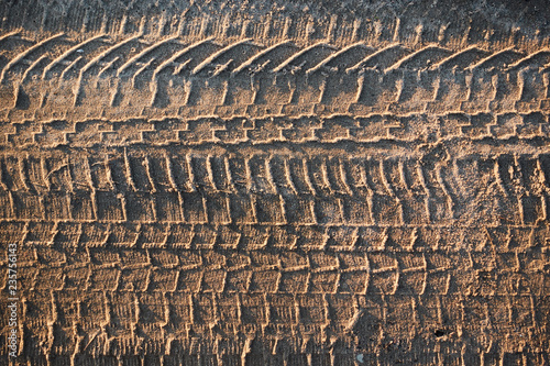 Traces of car tires on dry sand. Patterns in the sand