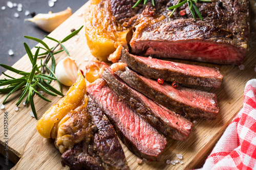 Grilled beef steak ribeye on wooden cutting board.  photo