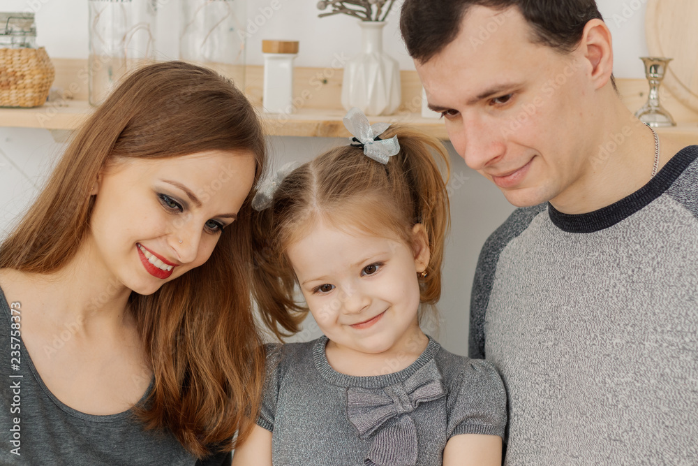 Fun and beautiful family of three having fun in the kitchen. Fun and beautiful family of three having fun in the kitchen.