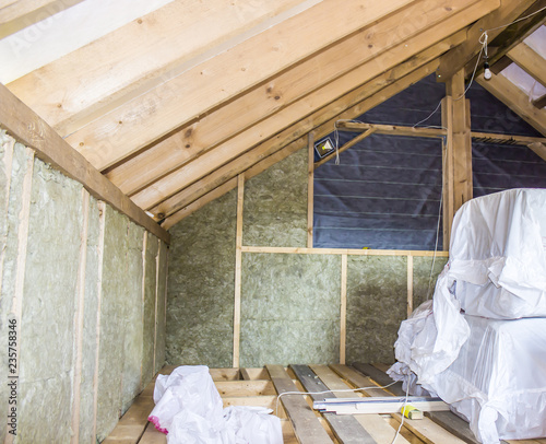 Construction - thermally insulating eco-wood frame house with wood fiber plates and heat-isolating natural hemp material. Finishing the walls with a white wooden board, using laser line level.