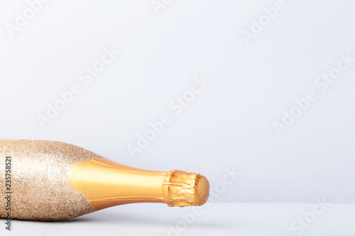 Decorated champagne bottle on grey background