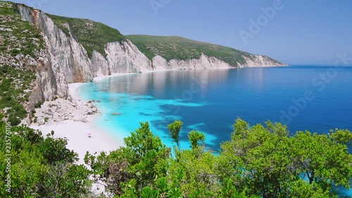 Blue lagoon with rocky coastline, Kefalonia, Greece. Calm clear blue emerald green turquoise sea water. White beach, summer feeling, vacation, travel in paradise. Amazing Ftery beach. photo