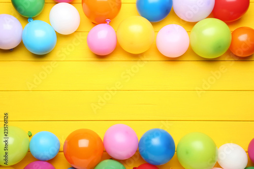 Colorful balloons on yellow wooden table