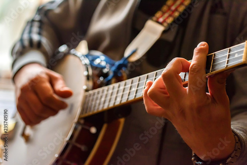 Foto Close up hands of man playing 8-string mandolin