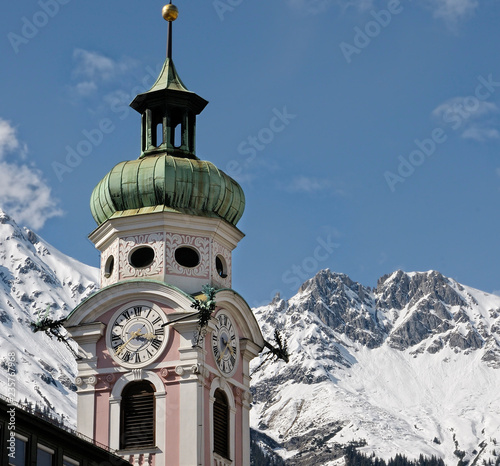 Spittalskirche in Innsbruck mit der beschneiten Nordkette im Hintergrund photo