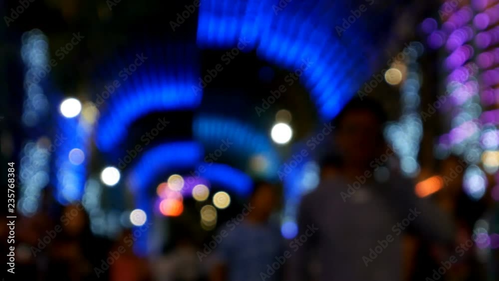 People walking street at night background, tunnel of blurred colorful bokeh light defocused background and textured for Christmas , New Year holidays party and celebration background