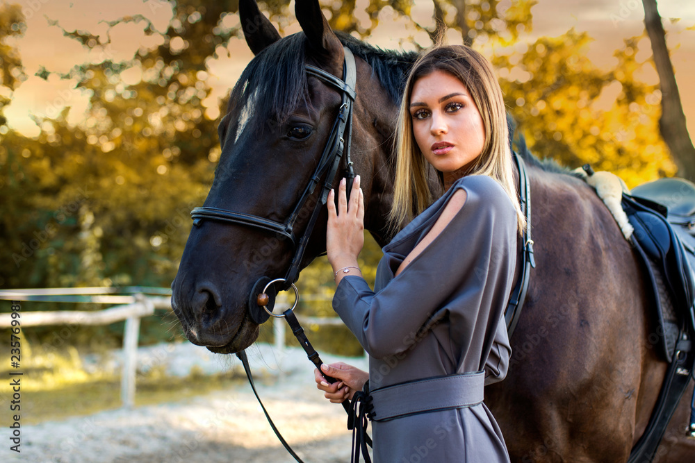 Obraz premium Young beautiful woman with a horse