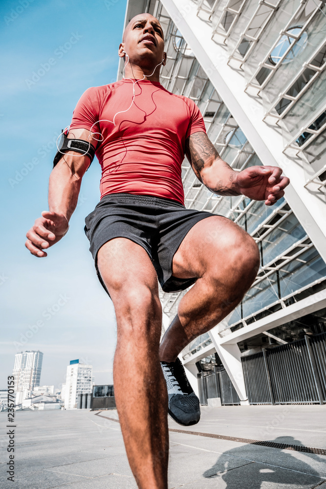 Smart handsome man running during his workout