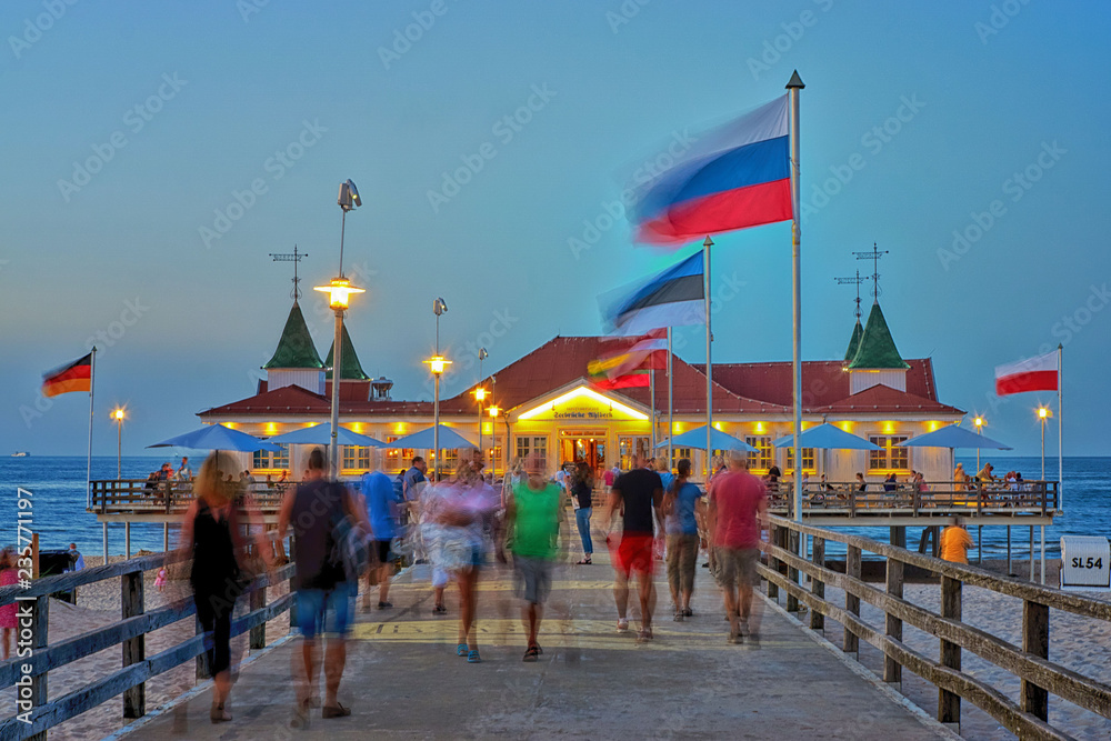 Pier Ahlbeck on the Baltic Sea with national flags in the wind. - Letters with Historische Seebrücke Ahlbeck means Ahlbeck Historic Pier.