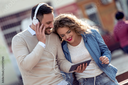 Couple listening to music outside on the tablet