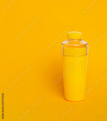 Yellow water bottle on a yellow background.
