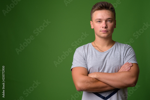 Studio shot of young handsome man against green background