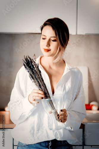 Young woman with lavender at kitchen at home