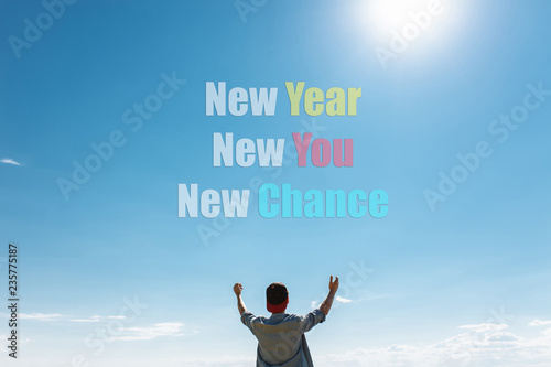 The guy pulls his hands to the sky on which the text. new year, new me, new chance. concept, christmas, motivation