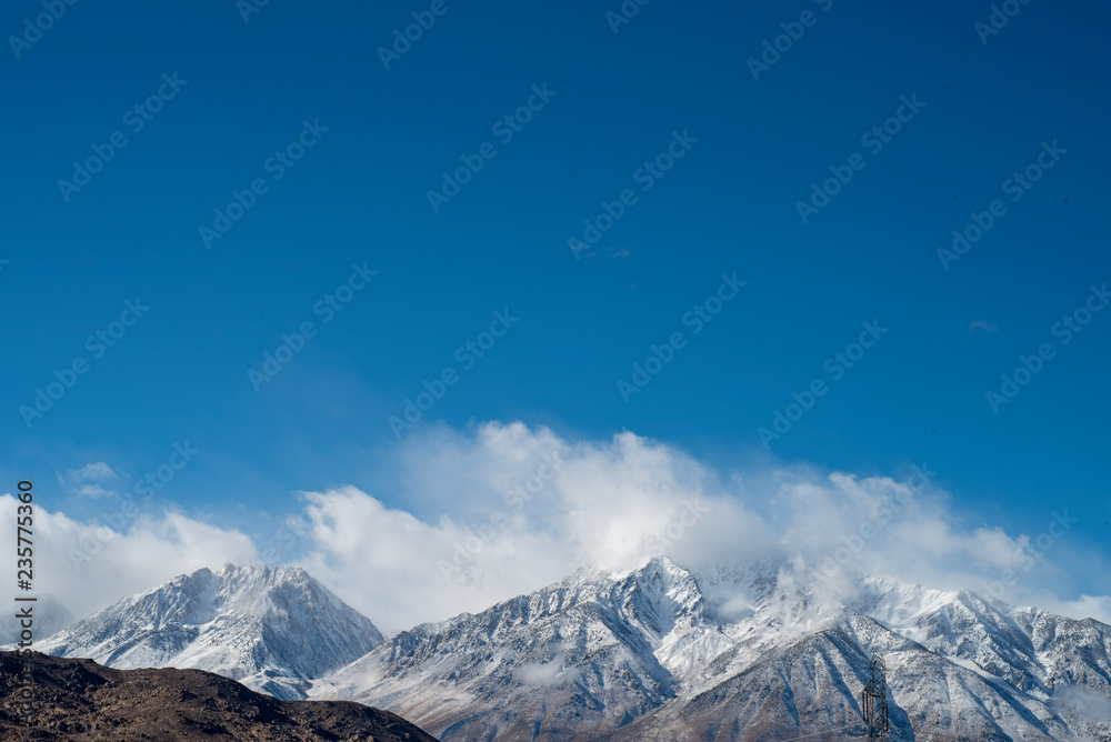 Obraz premium clouds and fresh fallen show on Eastern Sierra Nevadas, California, USA
