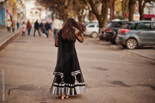 Pretty indian girl in black saree dress posed outdoor at autumn street.