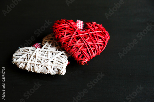 Fototapeta Naklejka Na Ścianę i Meble -  two  hearts red and white on black wooden table. Valentines, spring background. Mock up with copyspace. happy mothers day, romantic still life, 