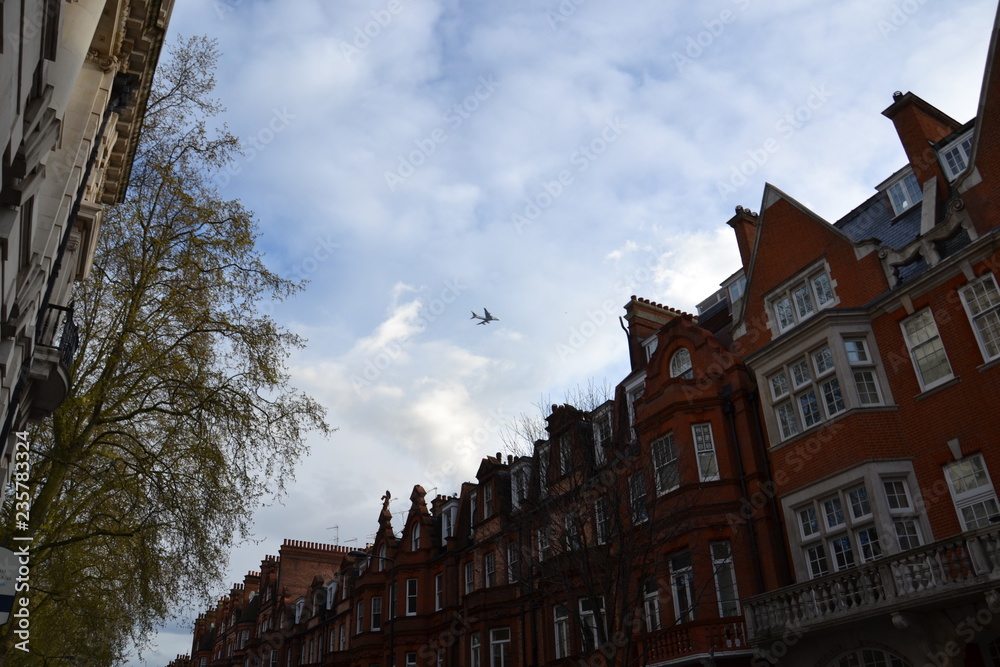 Obraz premium самолет пролетает над викторианскими домами в Лондоне