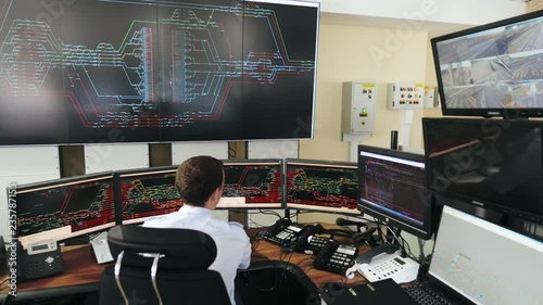 Man works in center for monitoring movement of trains on railway
