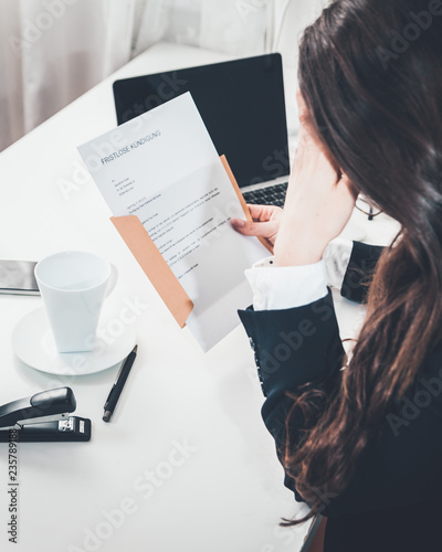 Frau erhält Brief mit fristloser Kündigung Entlassung Blick über die Schulter Brief in der Hand