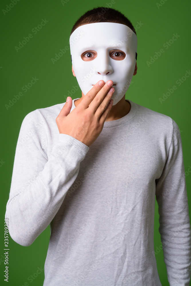 Studio shot of young handsome man against green background Studio shot of young handsome man against green background