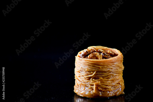 Middle Eastern dessert called mabroume or burma isolated on black background. photo