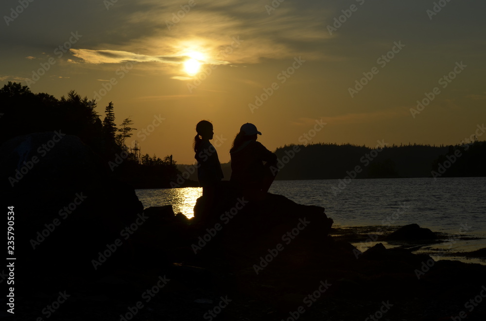 silhouette of man and woman on beach at sunset