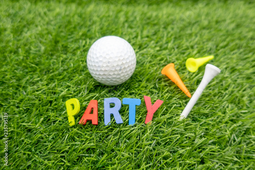 Golf Party invitation with golf ball and colourful tees on green grass