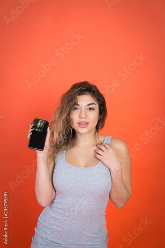 Studio shot of a beautiful young woman looking on camera while using cell phone