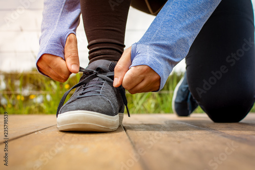 A young man lacing his shoe before a run early in the morning