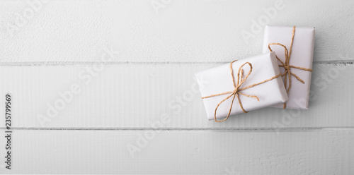 two white gift package on the white wooden table