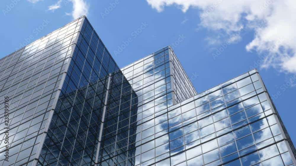 Office building with blue sky and clouds moving past. Time lapse.