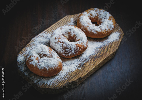 Tradition Jewish holiday sweets, donut sufganioyt with sugar powder on dark background photo