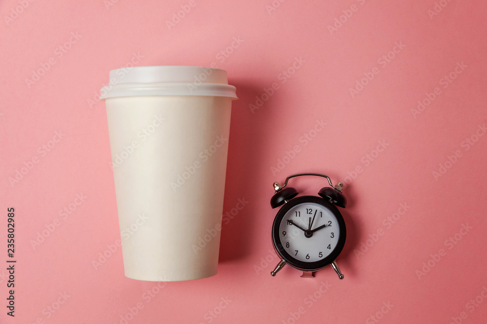 Simply flat lay design paper coffee cup and alarm clock on pink pastel colorful trendy background. Takeaway drink and breakfast beverage. Good morning wake up awake concept. Top view copy space Simply flat lay design paper coffee cup and alarm clock on pink pastel colorful trendy background. Takeaway drink and breakfast beverage. Good morning wake up awake concept. Top view copy space