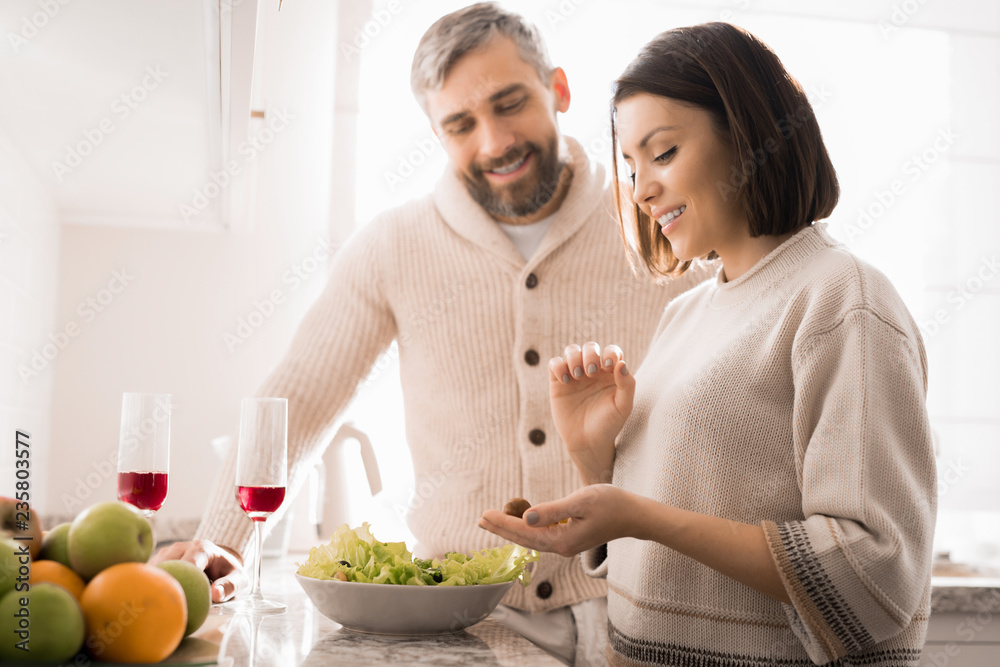 Φωτογραφία Waist up portrait of happy adult couple cooking together in kitchen lit by sunli