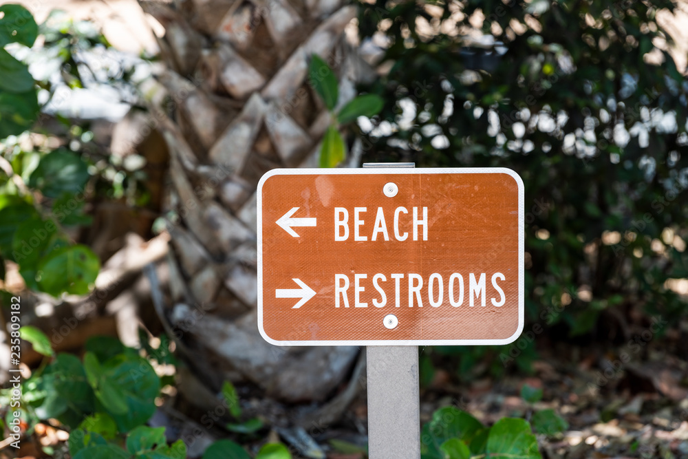 Beach Restrooms bathroom sign on street road in brown color in park on Sanibel Island, Florida