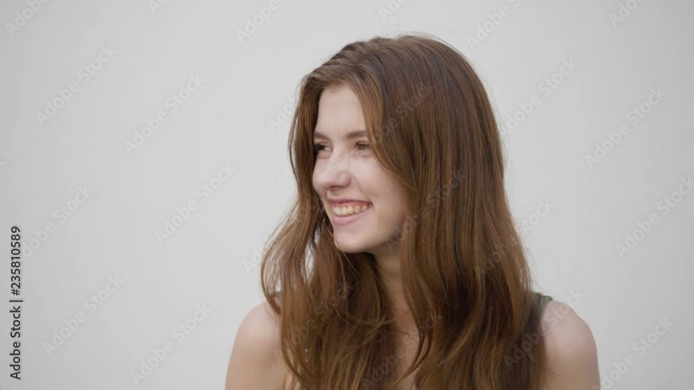 Slow motion shot of beautiful redhead girl showing different emotions, looking into camera, smiling, laughing. Medium close up. Slow motion shot of beautiful redhead girl showing different emotions, looking into camera, smiling, laughing. Medium close up.