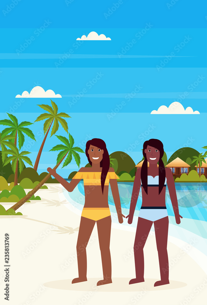 couple bikini women on tropical island with villa bungalow hotel on beach seaside green palms landscape summer vacation concept flat vertical