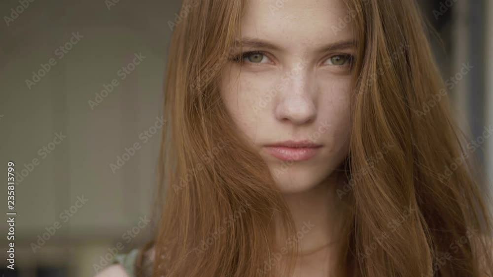 Slow motion shot of beautiful redhead girl showing different emotions, adorably smiling. Extreme close up. Slow motion shot of beautiful redhead girl showing different emotions, adorably smiling. Extreme close up.